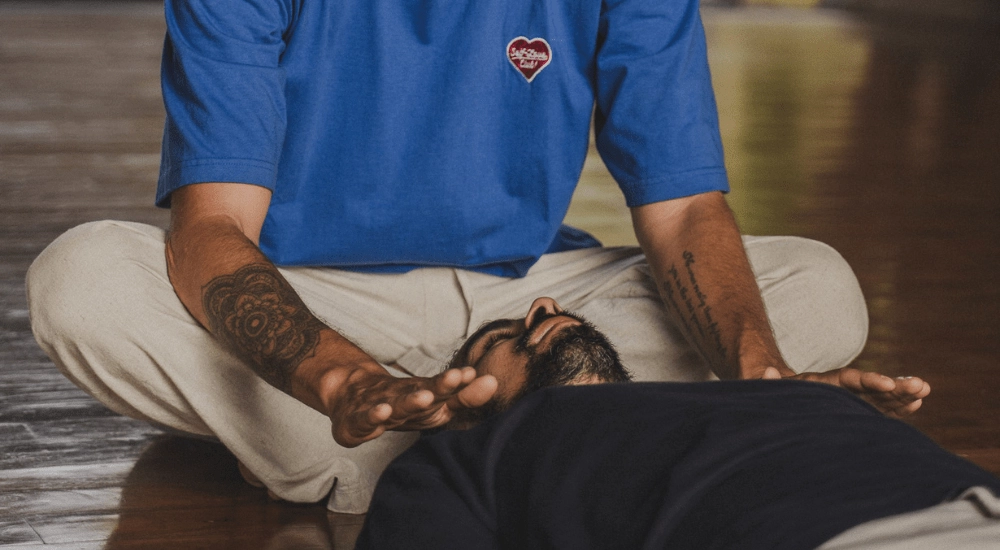 Ash performing reiki restorative yoga on a client